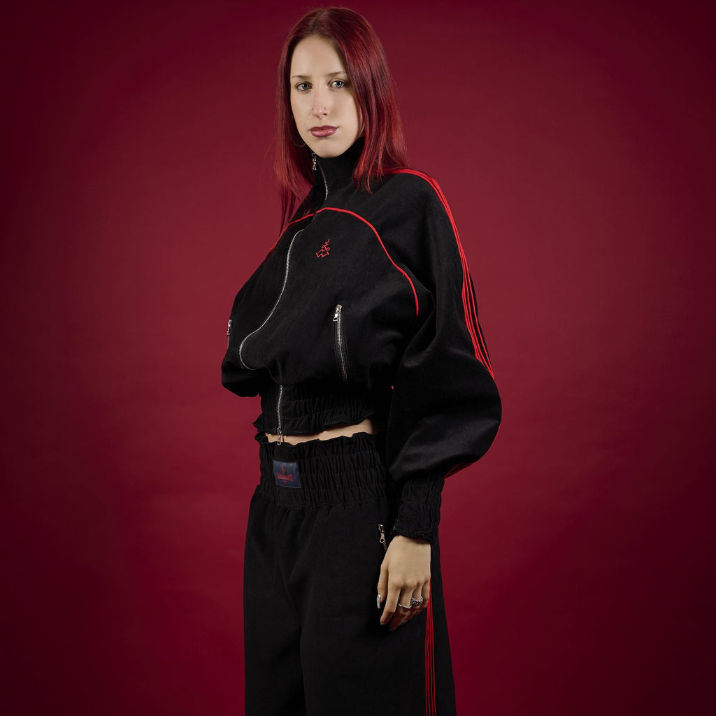 Person wearing a black outfit with red accents on a red background Lienhard VIII Muay Thai Tracksuit Women