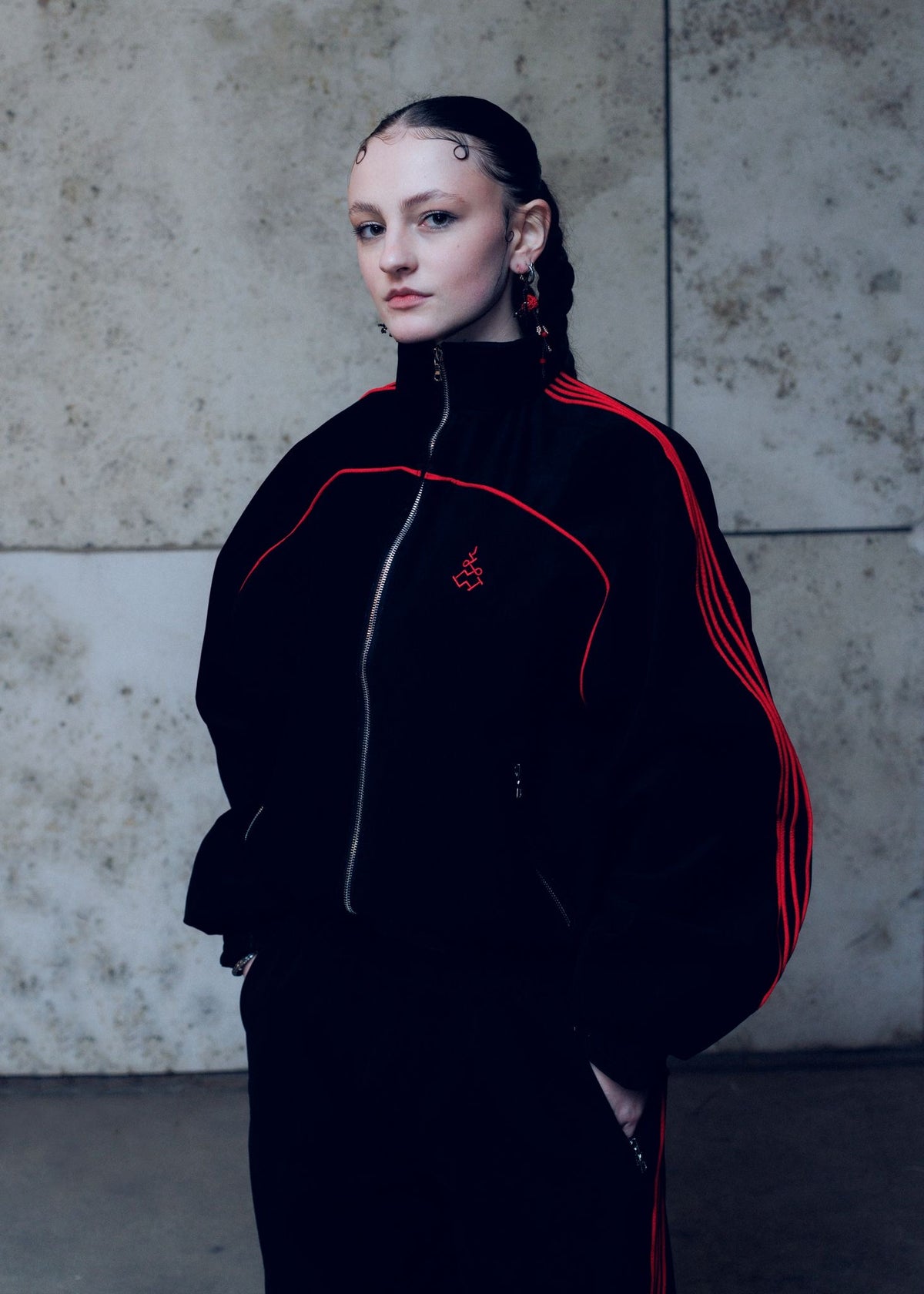 Aurora La Russa Person wearing a black and red tracksuit against a concrete wall. Muay Thai Streetwear Sak Yant Tattoo Thai Boxing Tracksuit Muay Thai